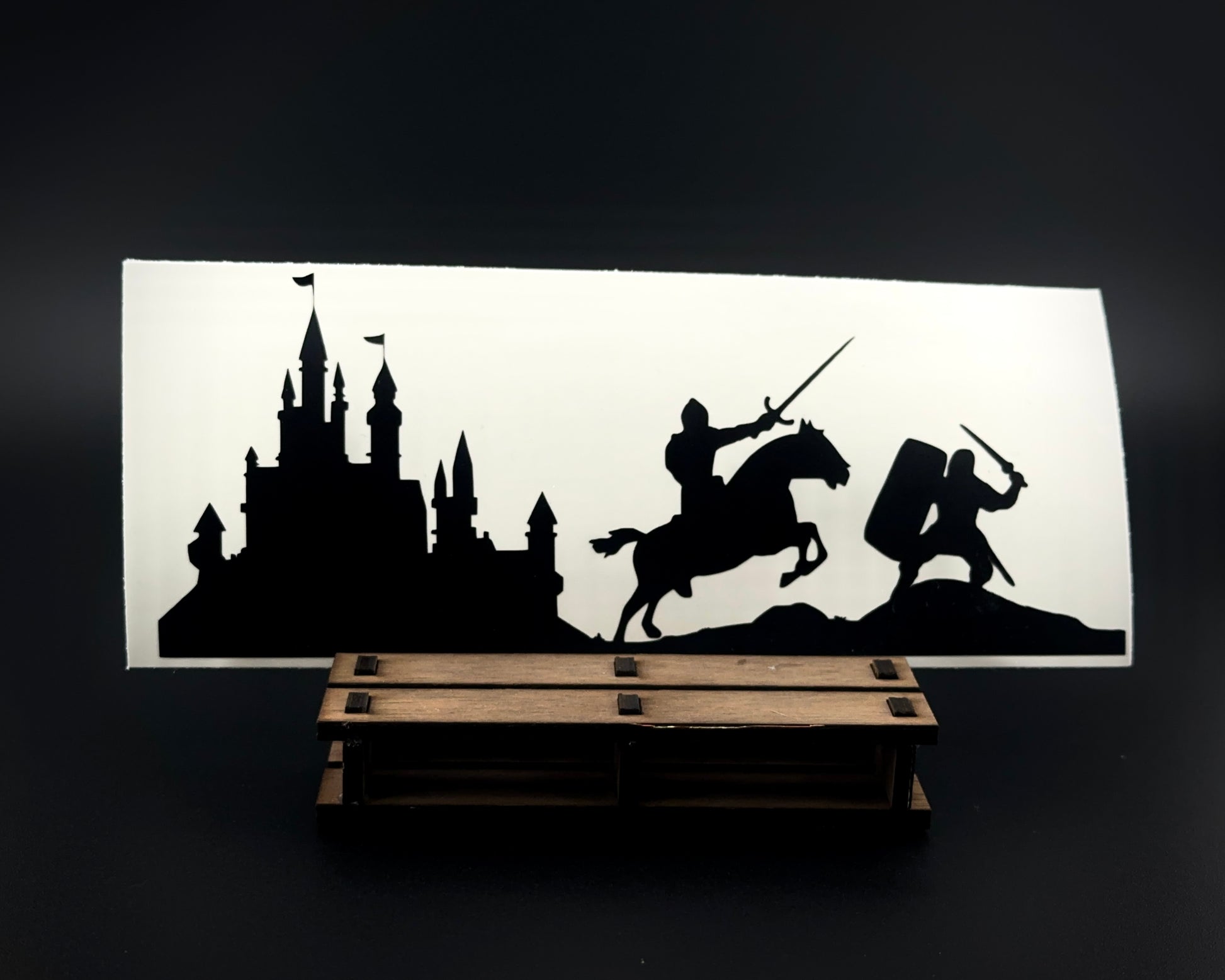 Medieval knight and castle vinyl decal featuring two knights in battle with swords, and a towering castle silhouette in the background. Matte black Oracal 651 vinyl.