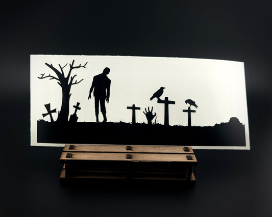 Matte black vinyl decal featuring a zombie walking in a graveyard with crosses, crows perched on gravestones, and a spooky hand reaching from the ground.