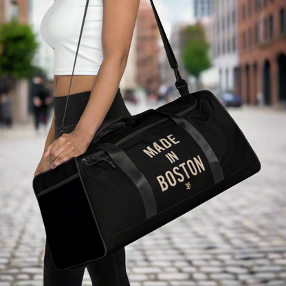 "Made in Boston" duffle bag, 100% polyester, adjustable padded shoulder strap, dual padded handles, mesh side pocket, and multiple inside pockets.